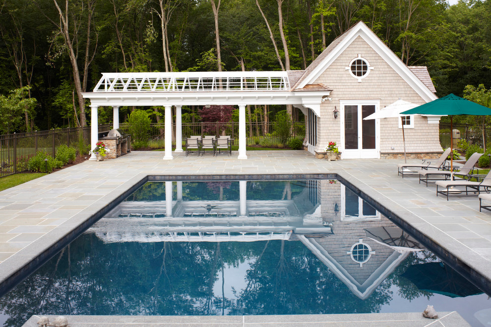 На фото: большой спортивный, прямоугольный бассейн на заднем дворе в классическом стиле с домиком у бассейна и покрытием из декоративного бетона
