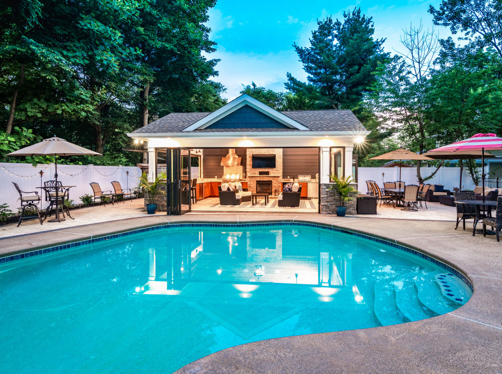 Ejemplo de casa de la piscina y piscina natural marinera de tamaño medio rectangular en patio trasero con losas de hormigón