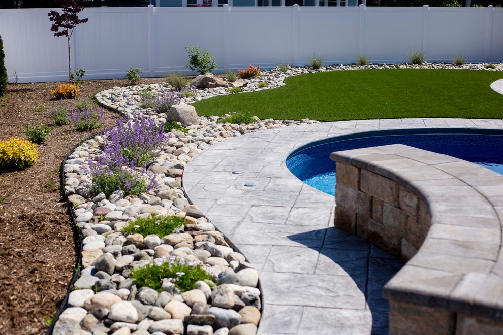 Diseño de piscina con fuente natural minimalista de tamaño medio a medida en patio trasero con adoquines de hormigón