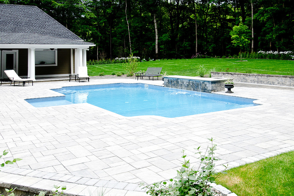 На фото: естественный бассейн среднего размера, произвольной формы на заднем дворе в современном стиле с фонтаном и покрытием из каменной брусчатки
