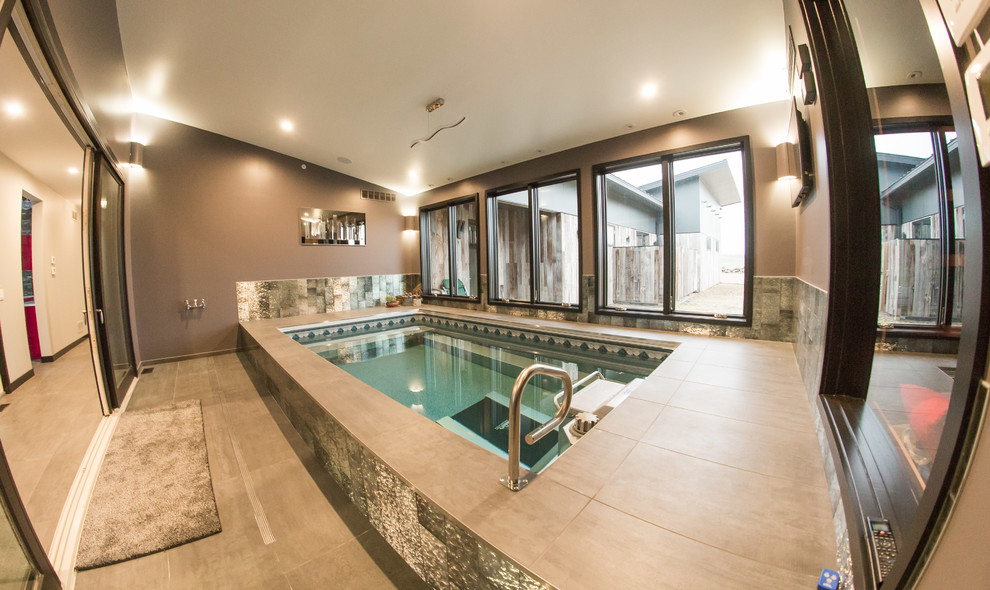 Example of a mid-sized trendy indoor stone and rectangular lap pool design in New York