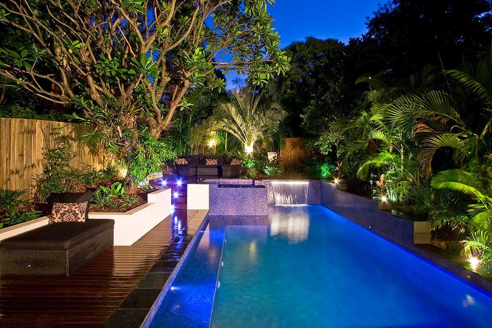 Mid-sized island style backyard custom-shaped aboveground hot tub photo in Brisbane with decking