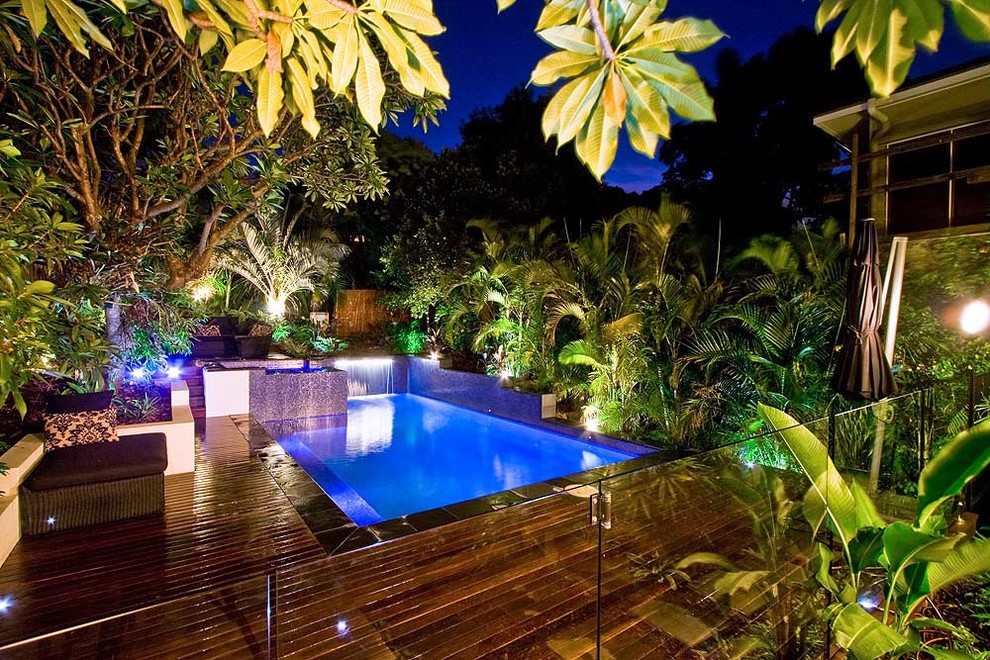 Ispirazione per una piscina fuori terra tropicale personalizzata di medie dimensioni e dietro casa con una vasca idromassaggio e pedane
