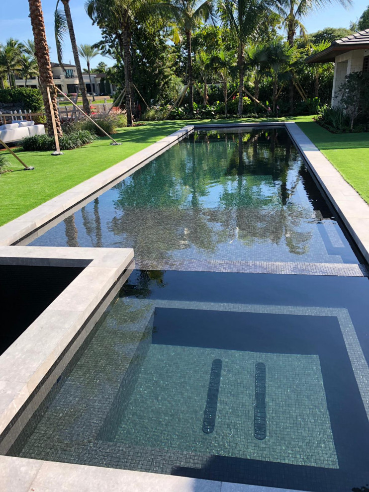 Foto di una grande piscina monocorsia contemporanea rettangolare dietro casa con una dépendance a bordo piscina e pedane
