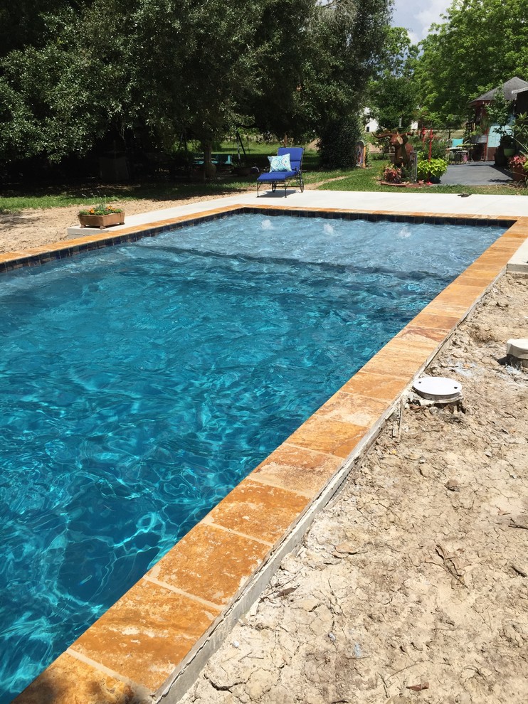 Modelo de piscina con fuente natural contemporánea pequeña rectangular en patio trasero con entablado