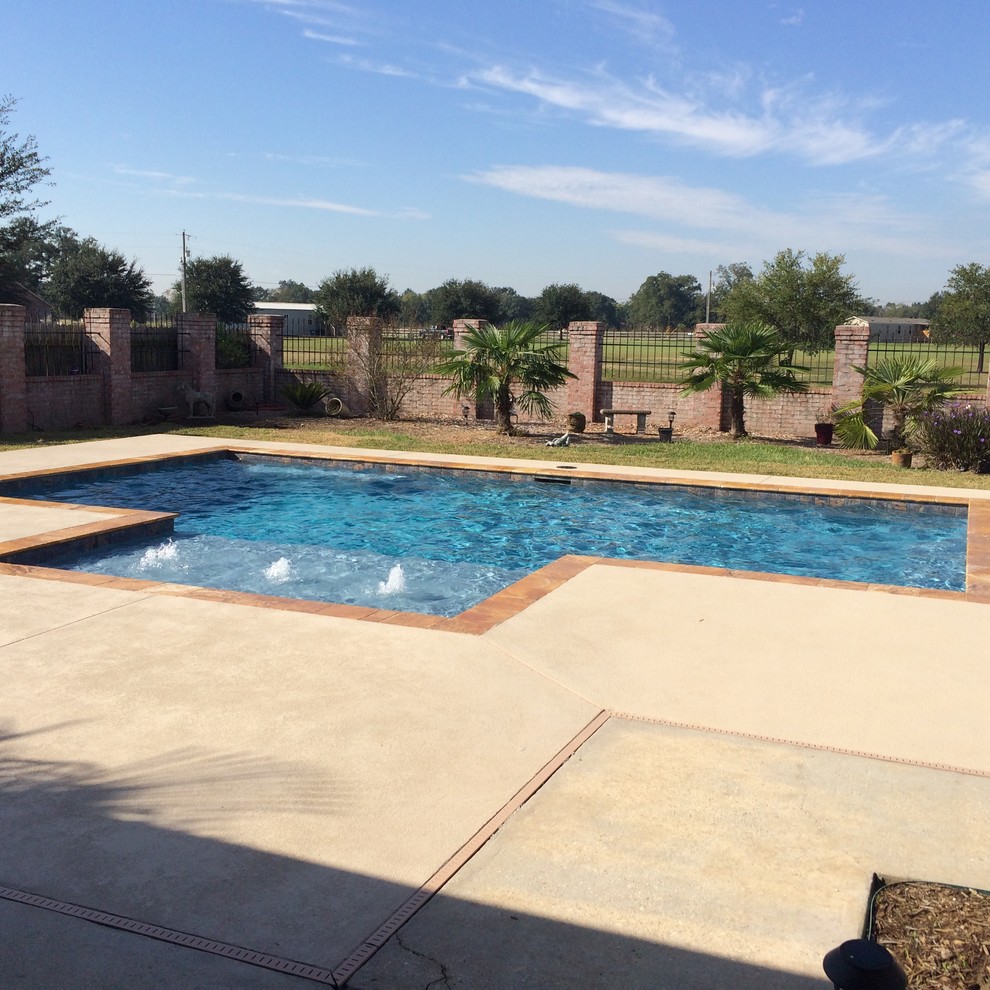 Foto di una piscina minimal rettangolare di medie dimensioni e dietro casa con fontane e pedane