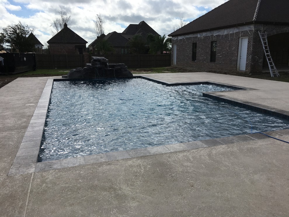 Ispirazione per una grande piscina naturale contemporanea rettangolare dietro casa con fontane e pedane