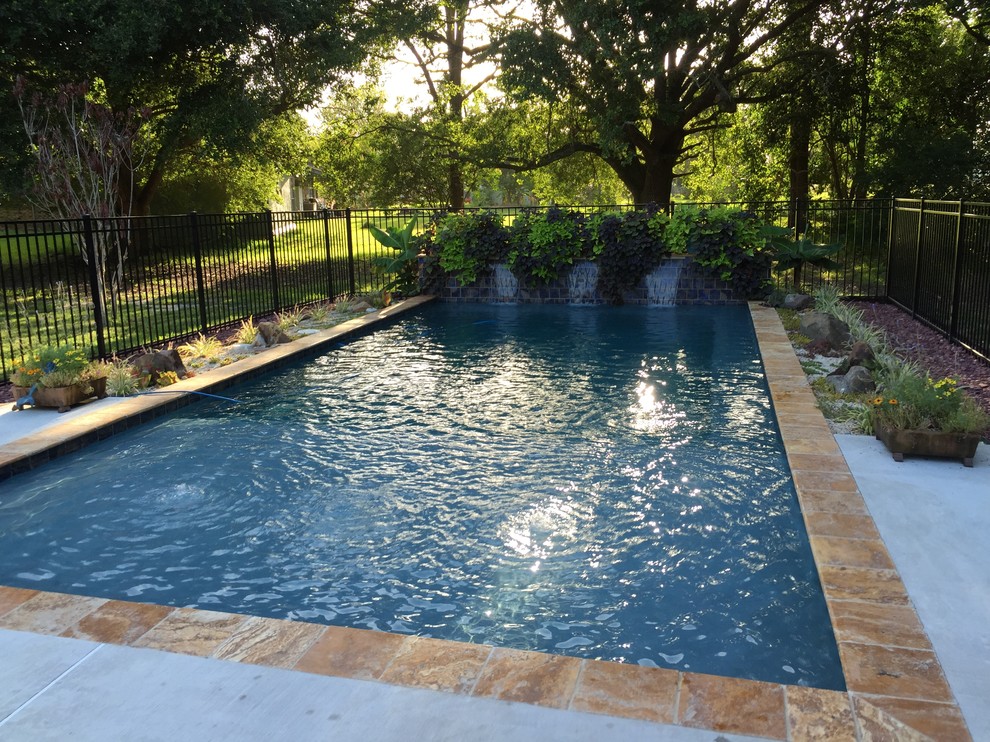 Diseño de piscina con fuente natural actual pequeña rectangular en patio trasero con entablado