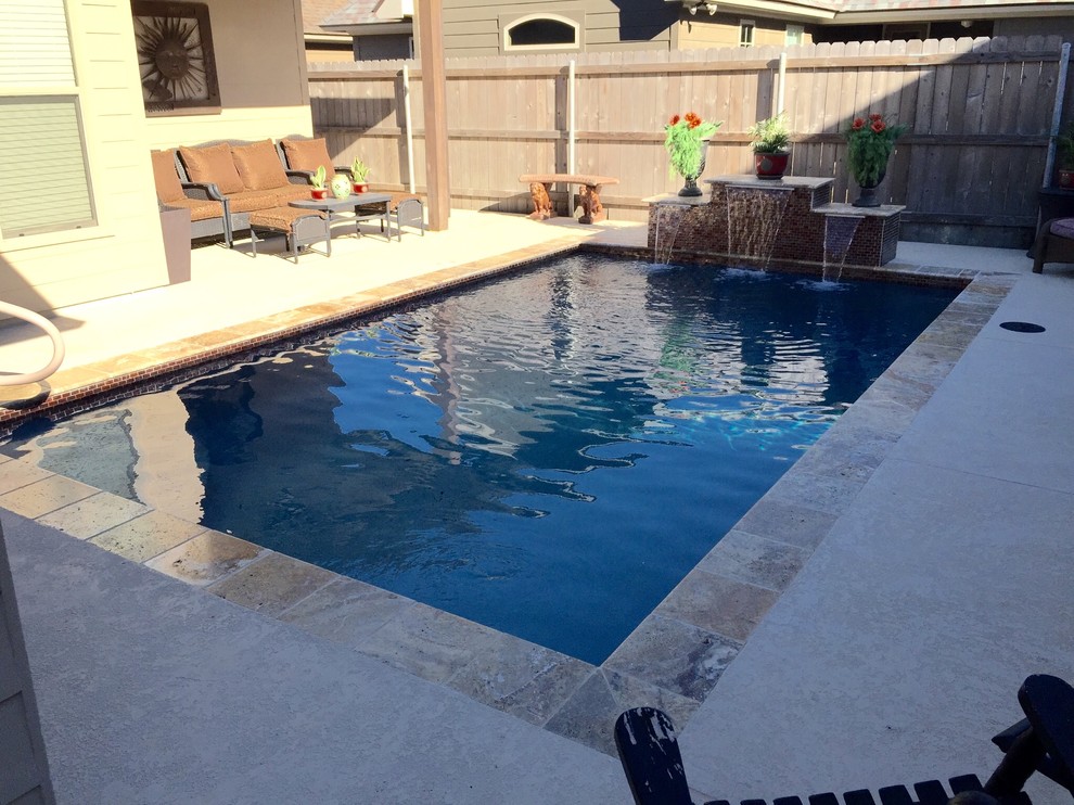 Ejemplo de piscina con fuente natural actual pequeña rectangular en patio trasero con entablado