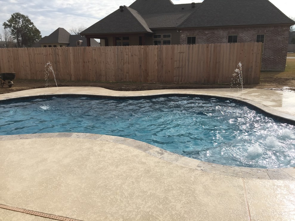 Foto di una piscina design personalizzata di medie dimensioni e dietro casa con fontane e pedane