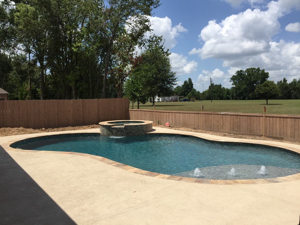 Diseño de piscinas y jacuzzis naturales actuales de tamaño medio a medida en patio trasero con entablado