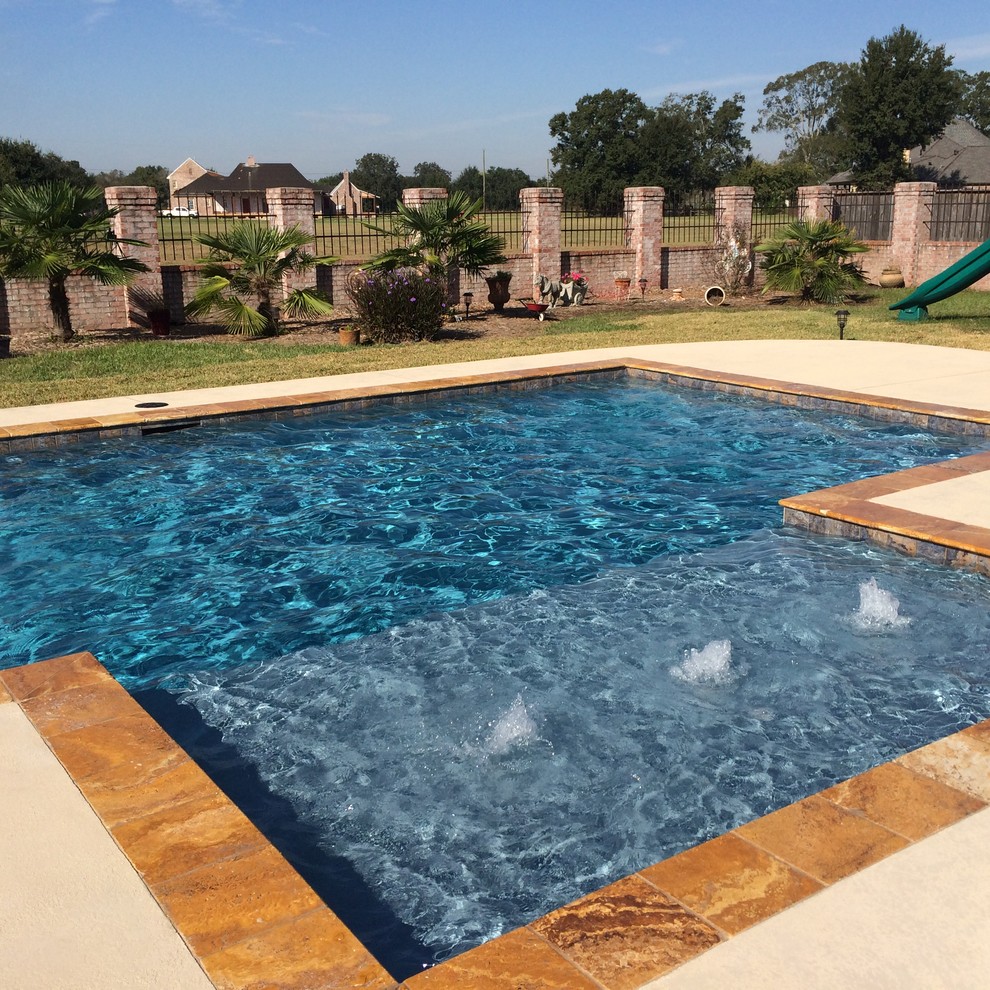 Modelo de piscina con fuente actual de tamaño medio rectangular en patio trasero con entablado