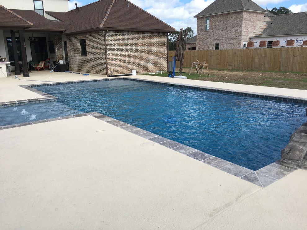 Diseño de piscina con fuente natural contemporánea grande rectangular en patio trasero con entablado