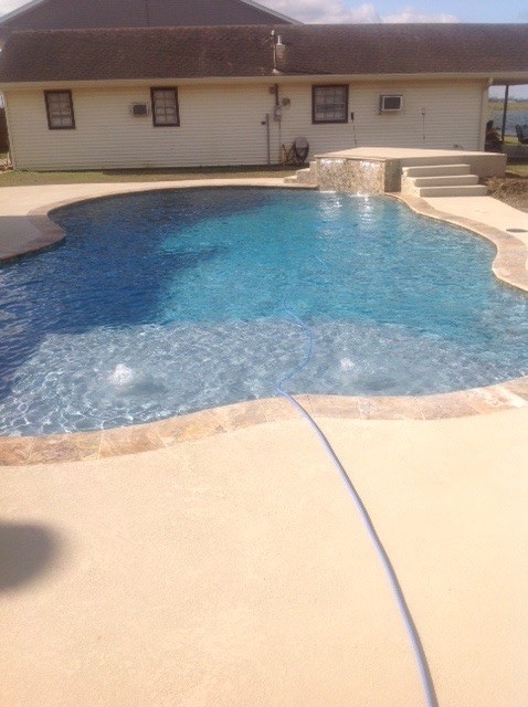 Pool fountain - large contemporary backyard custom-shaped natural pool fountain idea in New Orleans with decking