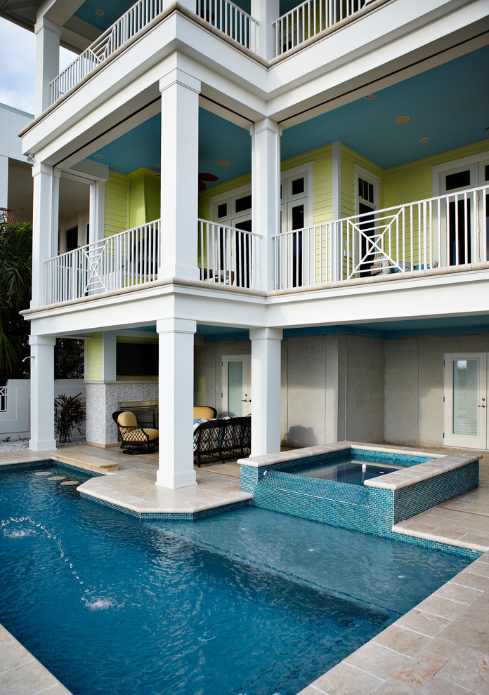 Imagen de piscina con fuente alargada actual grande rectangular en patio trasero con adoquines de piedra natural