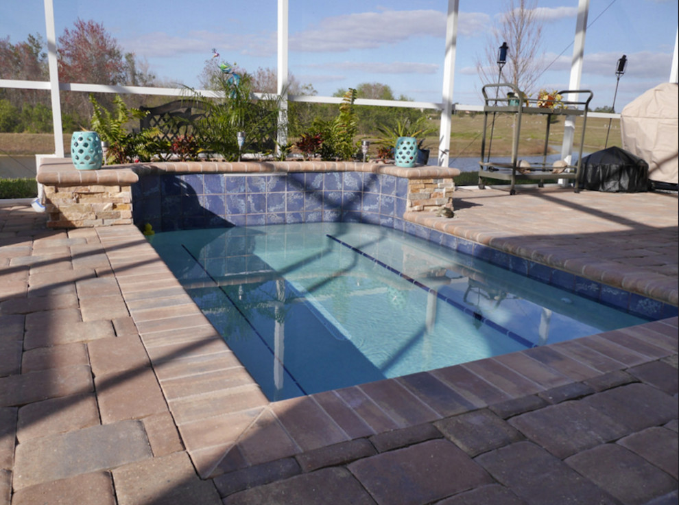 Diseño de piscinas y jacuzzis alargados clásicos renovados pequeños rectangulares en patio trasero con adoquines de ladrillo