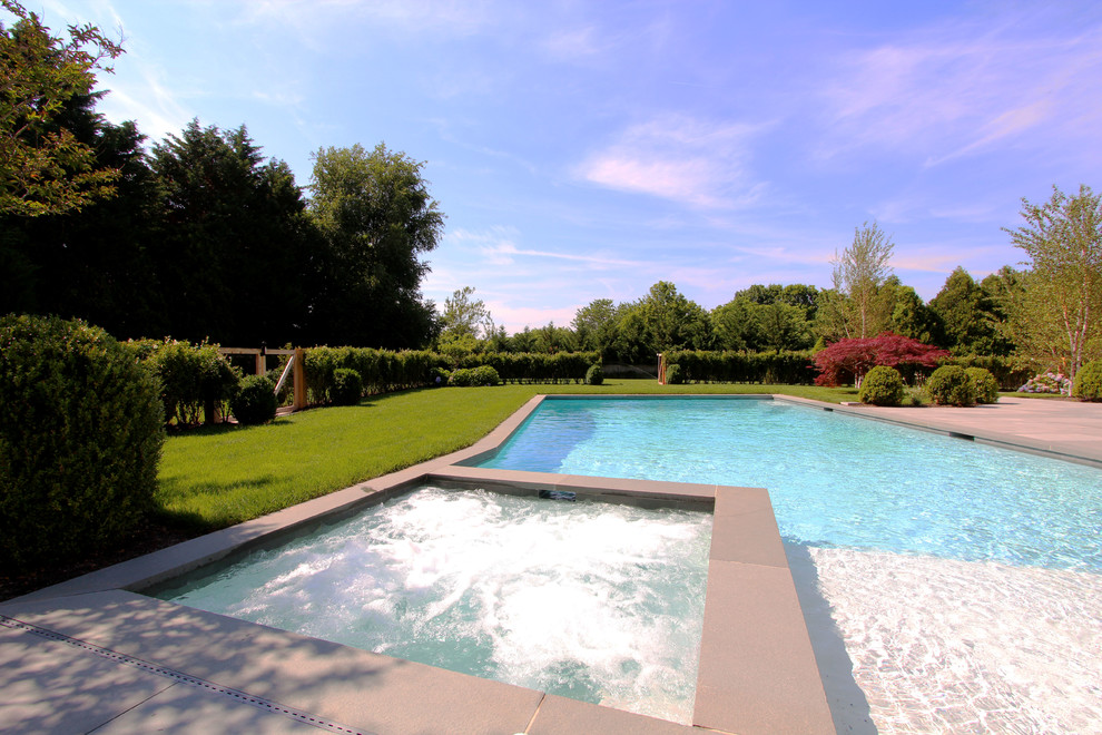 Ejemplo de piscinas y jacuzzis alargados costeros grandes rectangulares en patio trasero con suelo de baldosas
