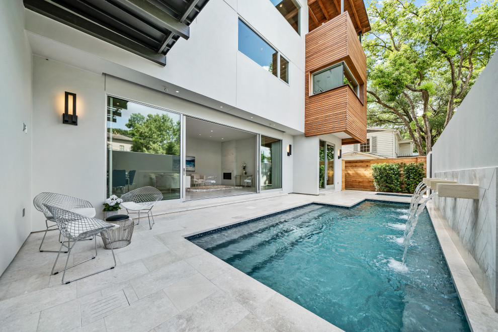 Inspiration för en mellanstor funkis anpassad pool på baksidan av huset, med en fontän och naturstensplattor