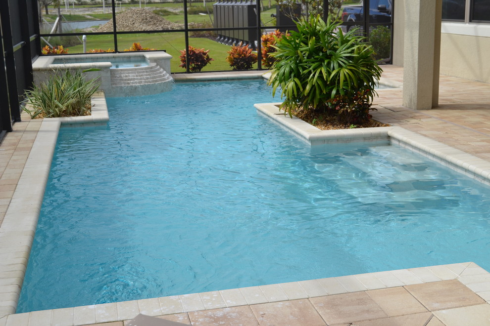 Exemple d'une piscine naturelle et arrière bord de mer de taille moyenne et rectangle avec des pavés en brique et un bain bouillonnant.