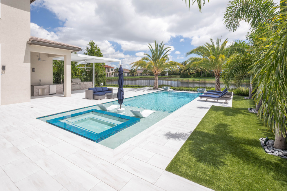 Cette image montre une grande piscine à débordement et arrière minimaliste rectangle avec un bain bouillonnant.