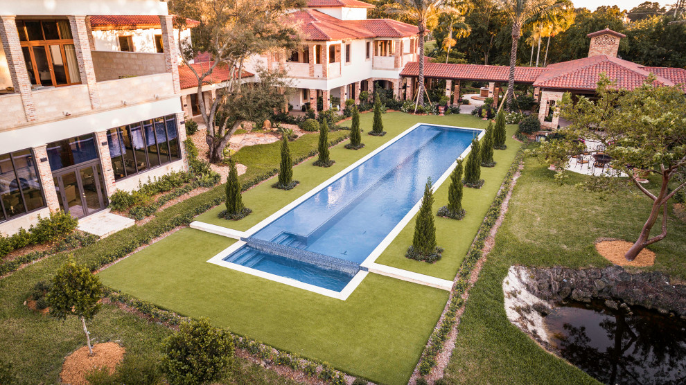 Diseño de piscina infinita minimalista extra grande rectangular en patio trasero