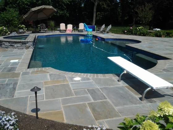 Pool - large traditional backyard rectangular pool idea in Newark with decking
