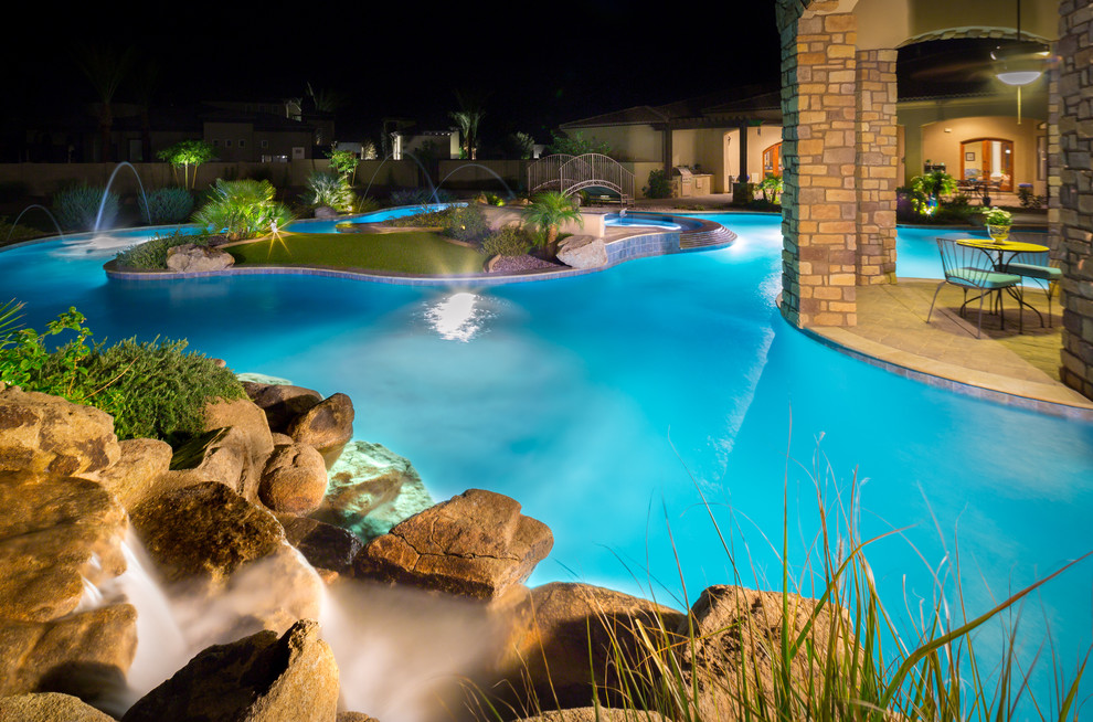 Идея дизайна: большой естественный бассейн произвольной формы на заднем дворе в средиземноморском стиле с мощением тротуарной плиткой