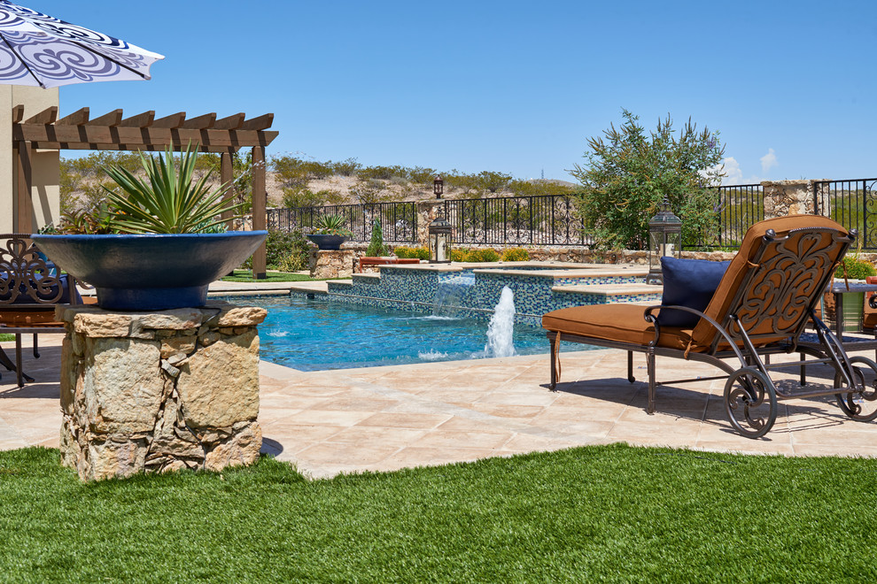 Esempio di una piscina naturale stile americano rettangolare di medie dimensioni e dietro casa con fontane e pavimentazioni in pietra naturale