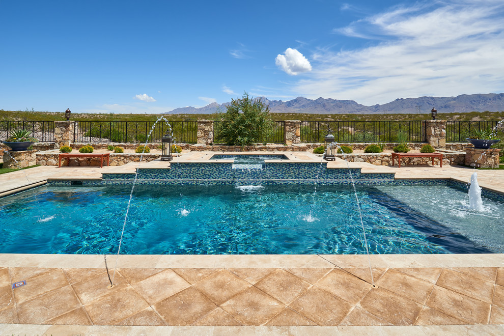 Cette photo montre une piscine naturelle et arrière sud-ouest américain de taille moyenne et rectangle avec un point d'eau et des pavés en pierre naturelle.