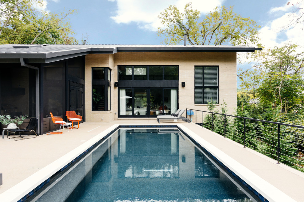 Ejemplo de piscina alargada retro de tamaño medio rectangular en patio trasero con losas de hormigón