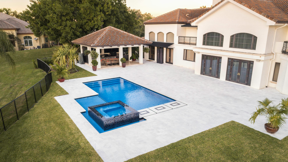 Esempio di una piscina monocorsia moderna rettangolare di medie dimensioni e dietro casa con una vasca idromassaggio