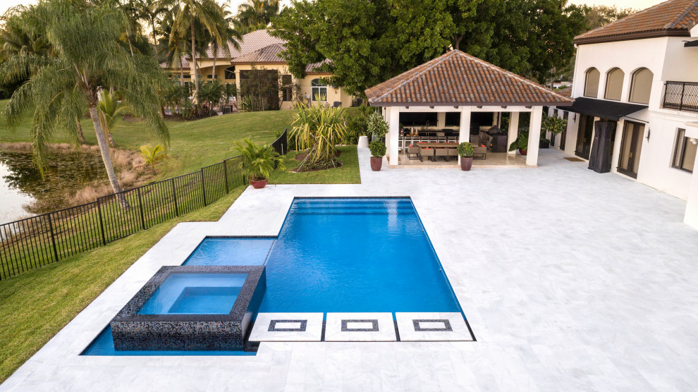 Esempio di una piscina monocorsia minimalista rettangolare di medie dimensioni e dietro casa con una vasca idromassaggio