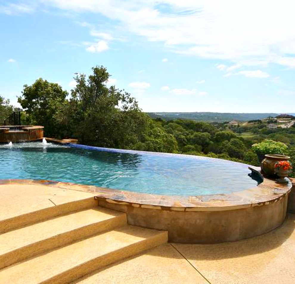 Foto de piscina con fuente infinita exótica de tamaño medio a medida en patio trasero con adoquines de piedra natural