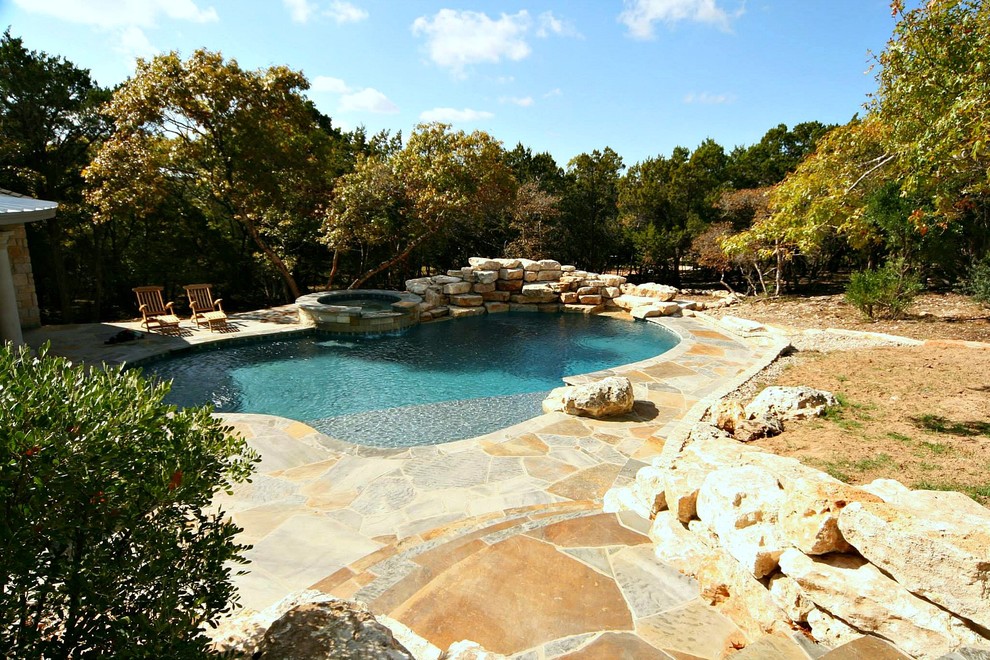 Diseño de piscinas y jacuzzis alargados exóticos grandes a medida en patio trasero con adoquines de piedra natural