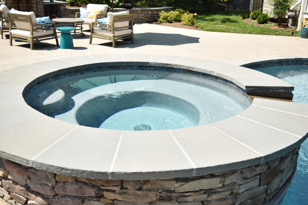 Свежая идея для дизайна: большой естественный бассейн в форме фасоли на заднем дворе в классическом стиле с джакузи и покрытием из декоративного бетона - отличное фото интерьера