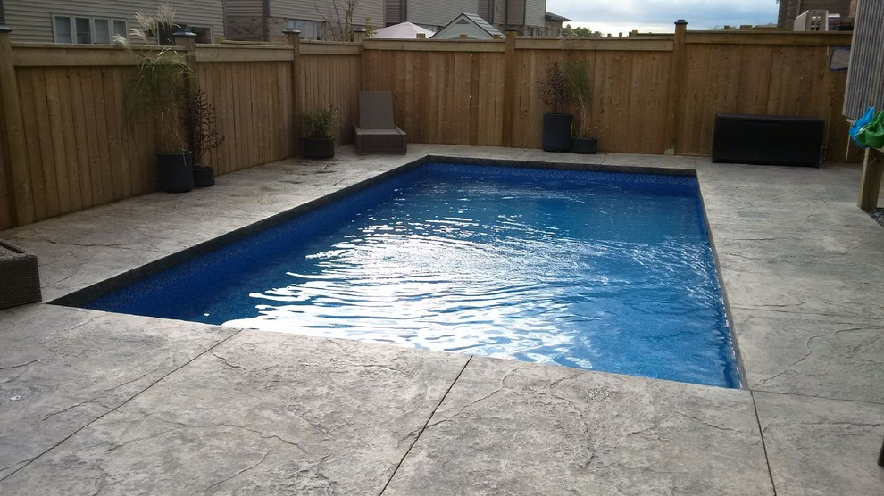 Ispirazione per una piscina monocorsia moderna rettangolare di medie dimensioni e dietro casa con lastre di cemento