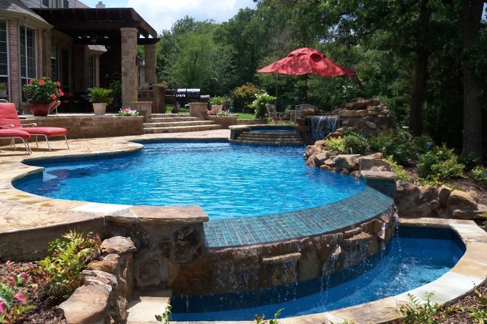 Classic back swimming pool in Dallas with a water feature.