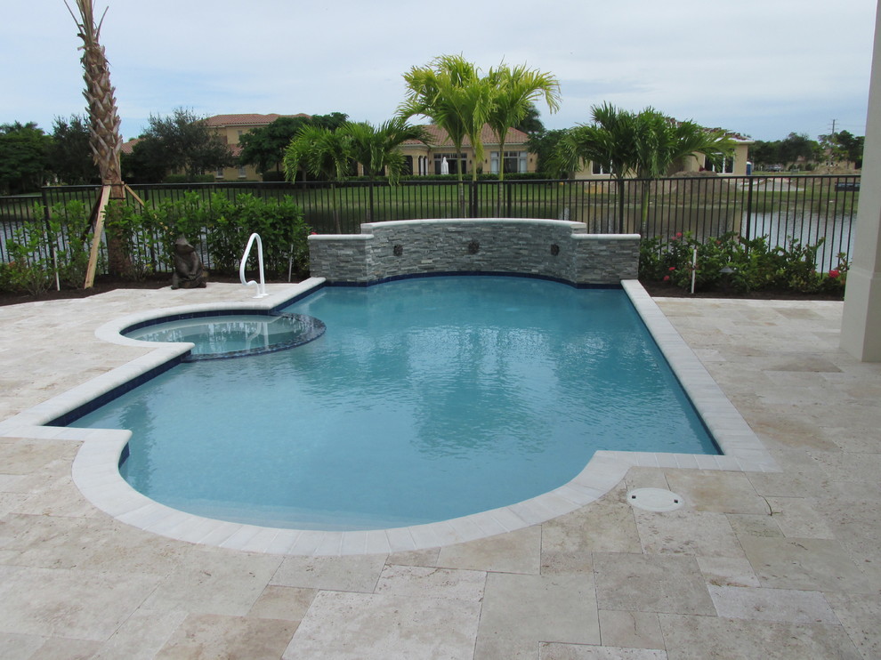 Ispirazione per una piscina moderna personalizzata di medie dimensioni e dietro casa con pavimentazioni in pietra naturale