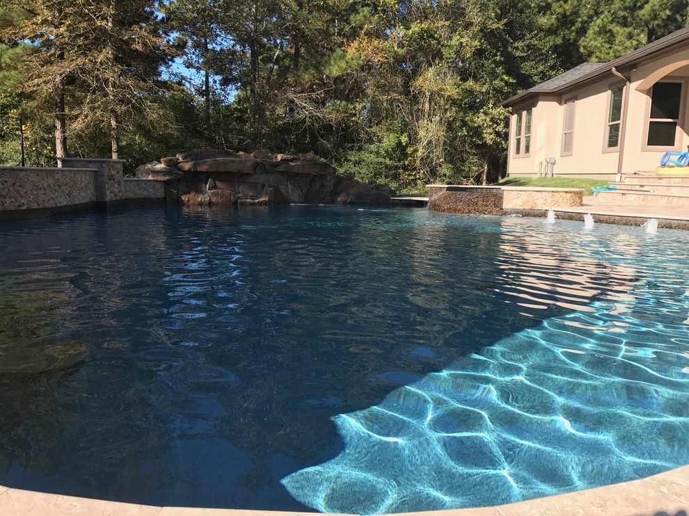 Ejemplo de piscinas y jacuzzis clásicos renovados grandes a medida en patio trasero con suelo de baldosas