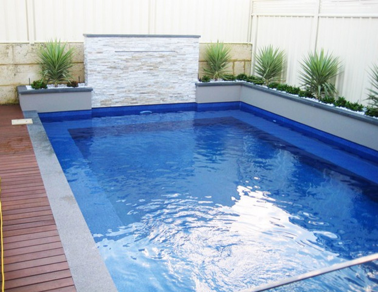 Réalisation d'une petite piscine minimaliste rectangle avec un point d'eau, une cour et une terrasse en bois.