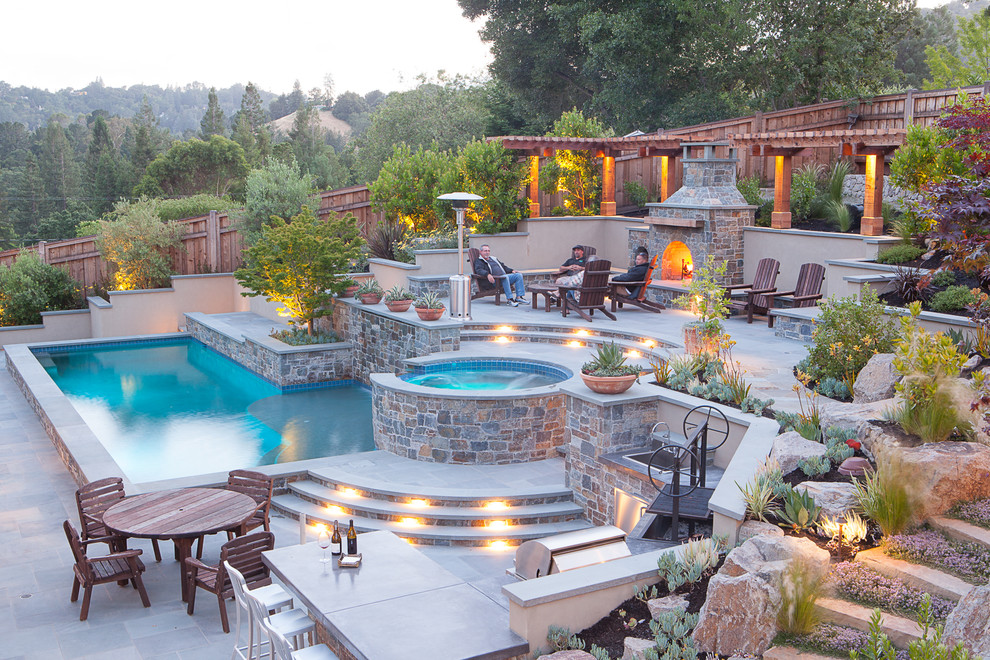 Foto de piscinas y jacuzzis clásicos renovados grandes en forma de L en patio trasero con adoquines de piedra natural