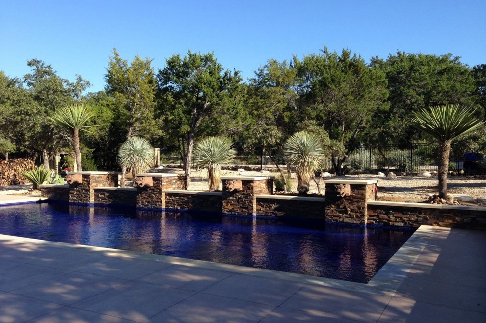 Imagen de piscina con fuente alargada mediterránea de tamaño medio rectangular en patio trasero con suelo de baldosas