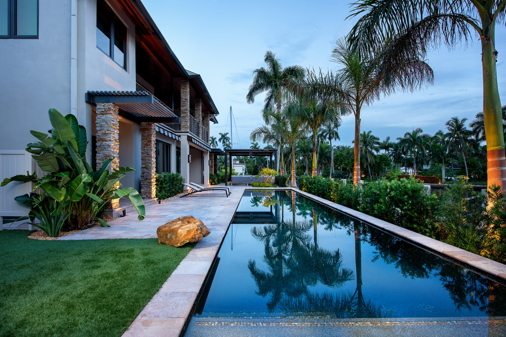 Idée de décoration pour une piscine arrière minimaliste de taille moyenne et rectangle avec des pavés en pierre naturelle.