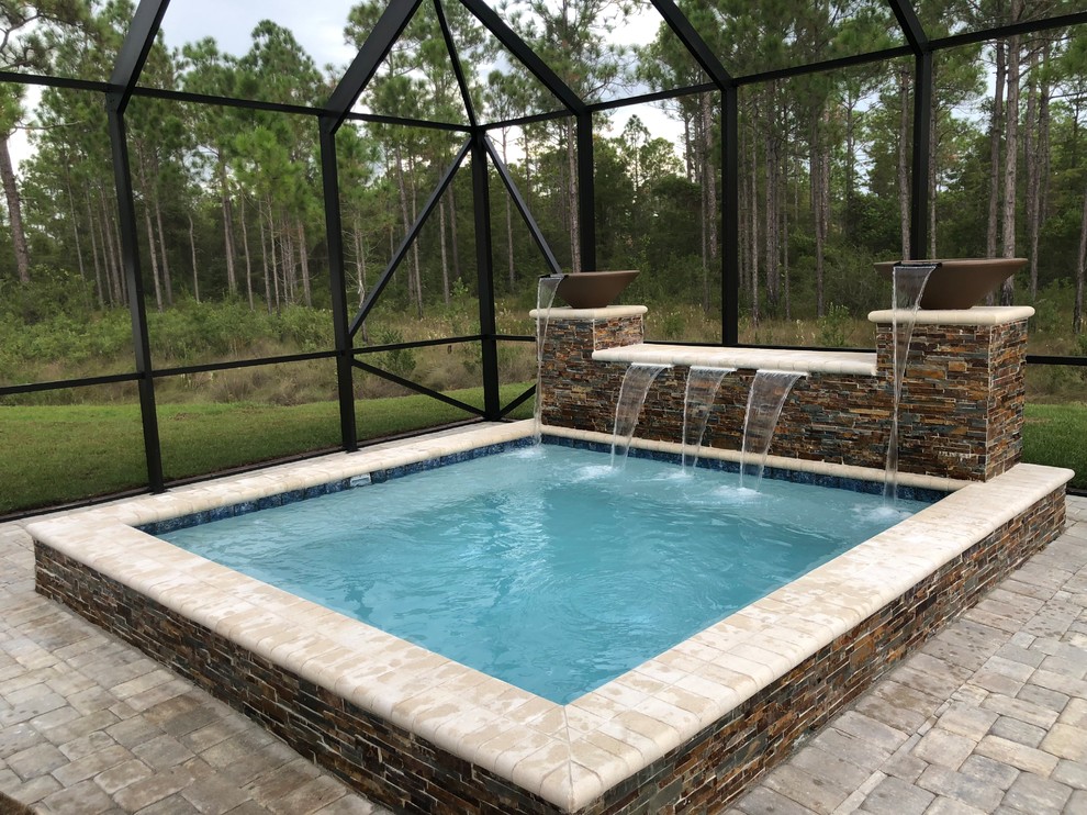 Modelo de piscinas y jacuzzis rústicos pequeños rectangulares en patio trasero con adoquines de hormigón