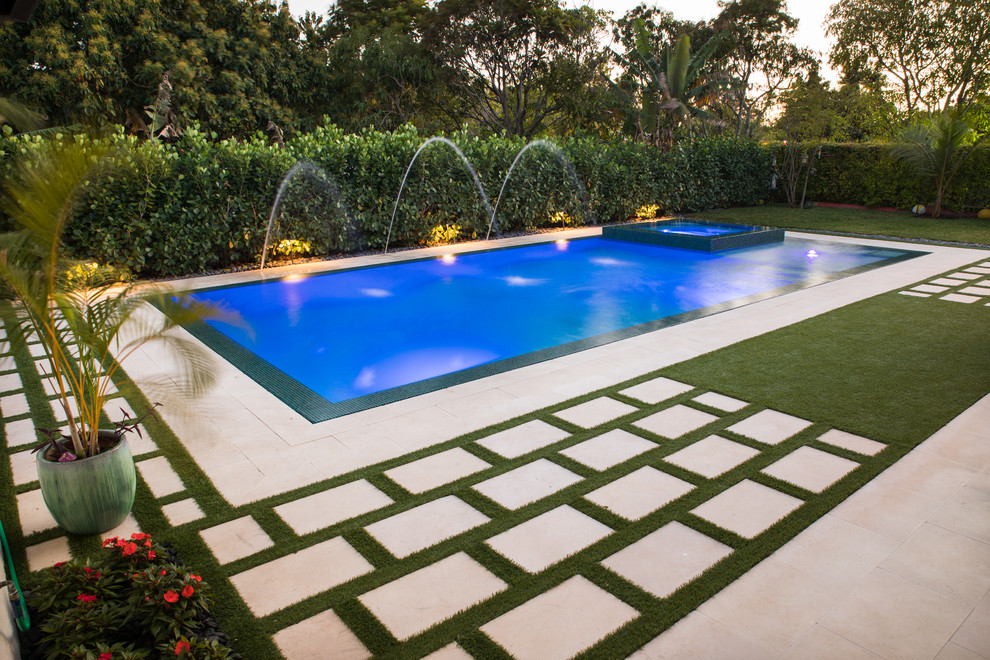 Example of a large trendy backyard rectangular lap pool fountain design in Miami