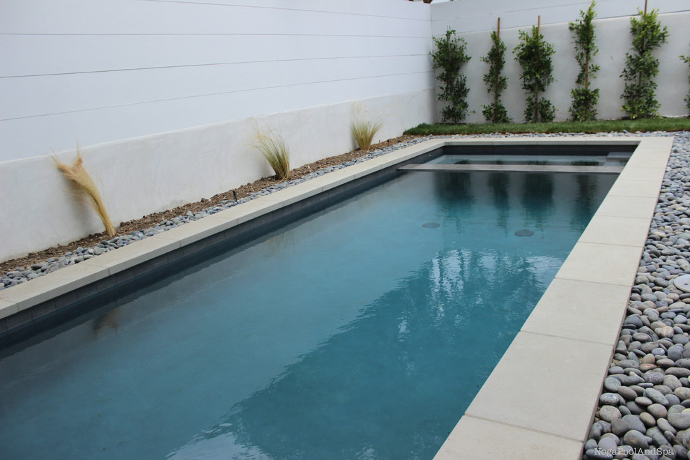 Foto de piscinas y jacuzzis alargados minimalistas de tamaño medio a medida en patio trasero con suelo de hormigón estampado