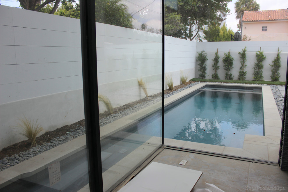 Exemple d'un couloir de nage arrière moderne de taille moyenne et sur mesure avec un bain bouillonnant et du béton estampé.