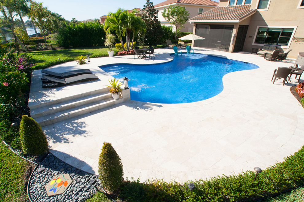 Großer Maritimer Pool hinter dem Haus in individueller Form mit Wasserspiel und Natursteinplatten in Miami