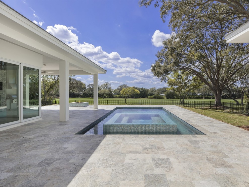 Diseño de piscinas y jacuzzis elevados tradicionales renovados de tamaño medio rectangulares en patio trasero con adoquines de piedra natural