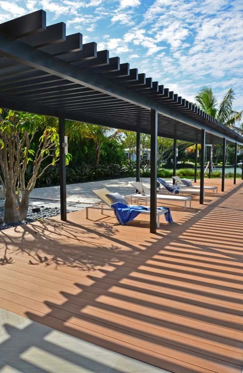 Large backyard rectangular lap hot tub photo in Miami with decking
